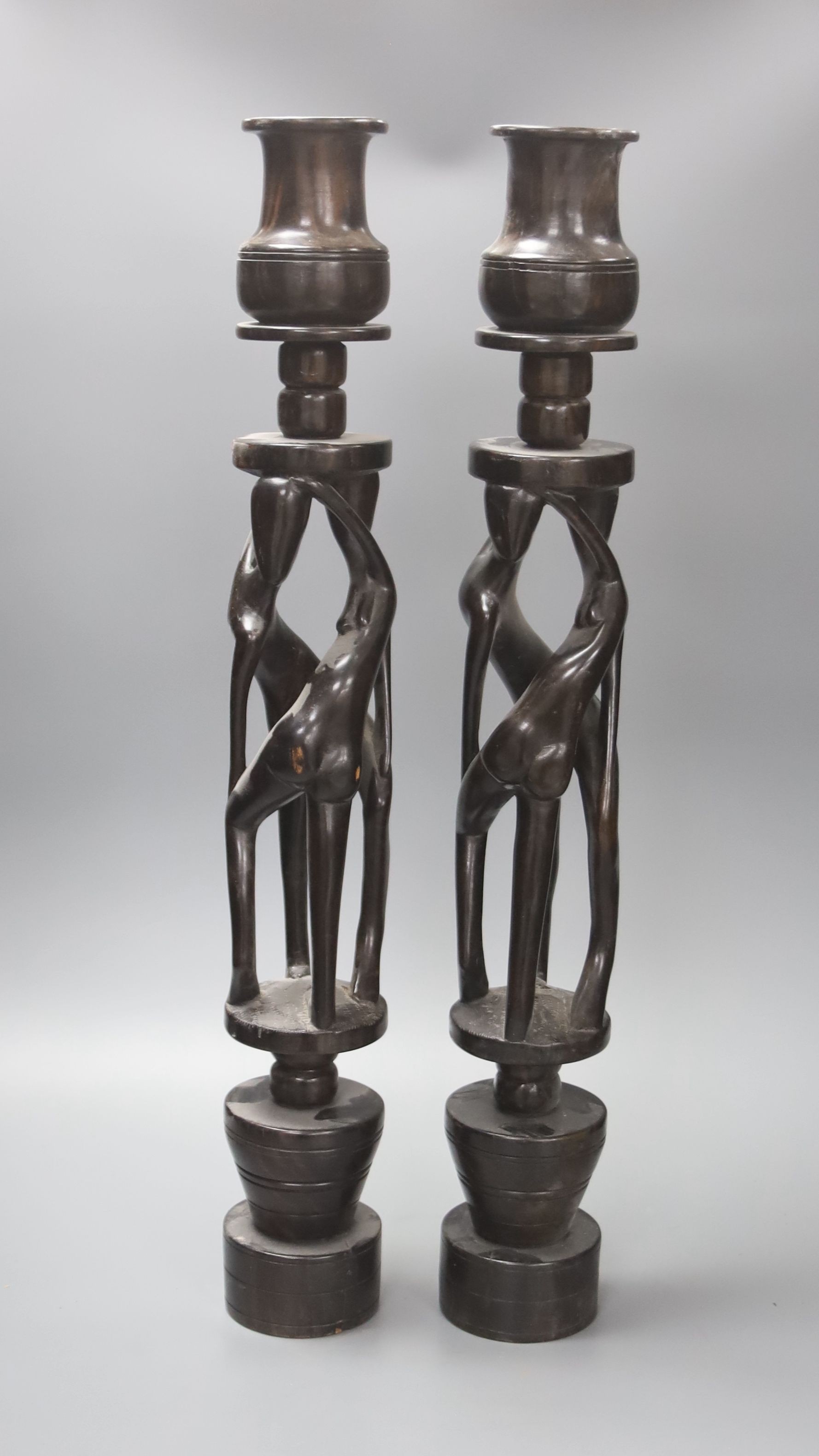 A pair of African tribal figural ebony candlestands, 60cm